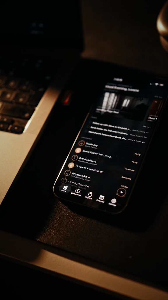 Posthive companion app on a phone, resting on a laptop
